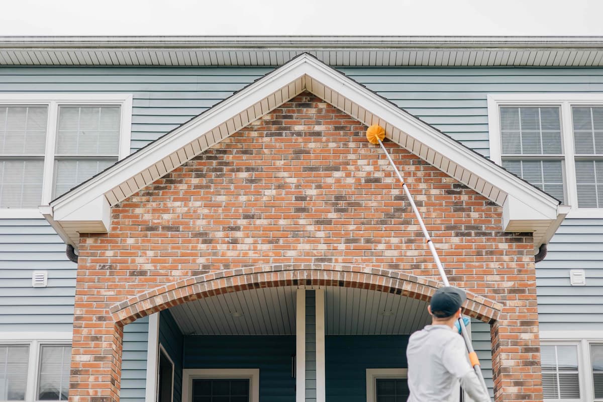 Ruva Pest Control technician performing exterior treatment on a home in Foxborough, MA